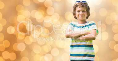 Portrait of confident boy standing arms crossed over bokeh