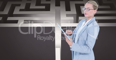 Confident businesswoman using tablet PC against maze