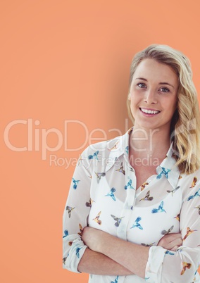 Portrait of casual businesswoman standing arms crossed against orange background
