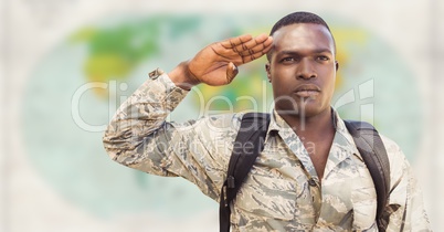 Soldier with backpack saluting against blurry map