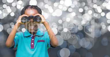 Happy girl holding binoculars over defocused background