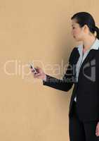 Businesswoman using mobile phone over beige background