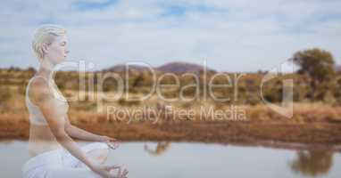 Double exposure of woman meditating by lake
