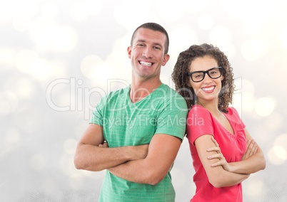 Portrait of smiling business people standing arms crossed against bokeh