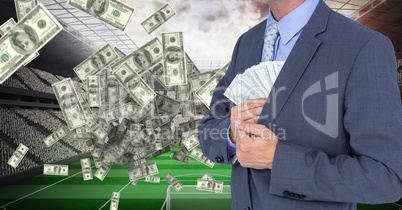 Midsection of businessman hiding money at football stadium representing corruption