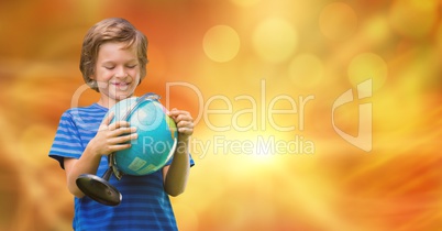 Smiling boy looking at globe over bokeh