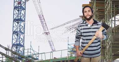 Hipster holding ax at construction site