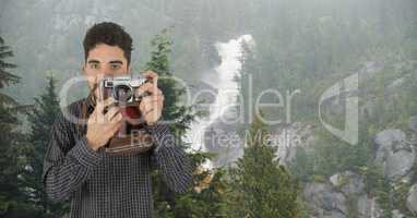 Portrait of male hiker photographing through camera against mountain