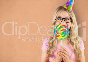 Portrait of female hipster covering mouth with candy against orange background