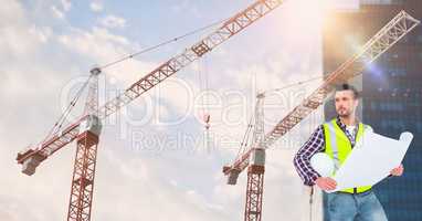 Architect holding blueprint by cranes