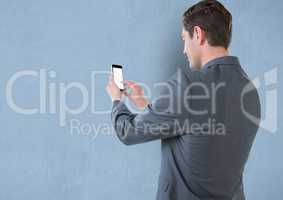 Rear view of businessman touching blank screen of mobile phone