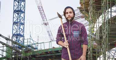 Hipster holding ax at construction site