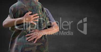 Back of soldier hugging against grey wall