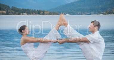 Double exposure of man and woman performing yoga exercising over lake