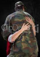 Back of soldier being hugged against black background