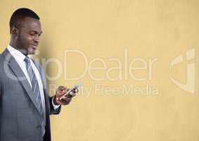 Businessman using mobile phone over beige background