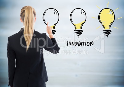 Back of business woman pointing at lightbulb doodle against blurry blue wood panel