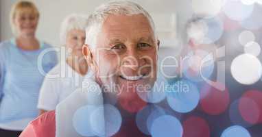 Smiling senior man with friends in yoga class