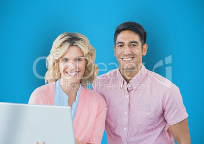 Portrait of happy business people with laptop against blue background