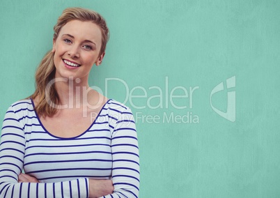 Smiling woman with arms crossed over turquoise background