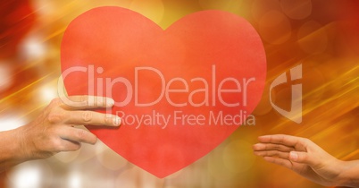 Cropped image of man giving heart shape to woman against bokeh