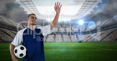 Soccer player with ball waving hand on field