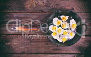 Fried quail eggs in a cast-iron black frying pan