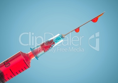 Syringe with red liquid against blue background