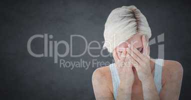 Woman crying in hands against grey background with grunge overlay