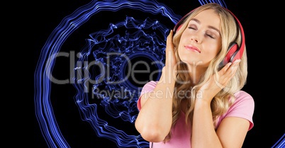 Young woman listening music through headphones against abstract background
