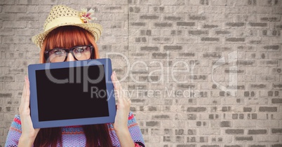 Female hipster showing blank device against wall