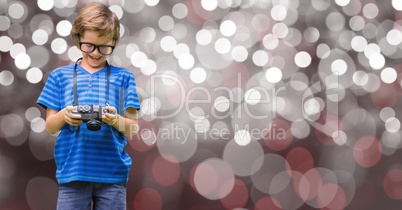 Boy watching pictures on camera over bokeh