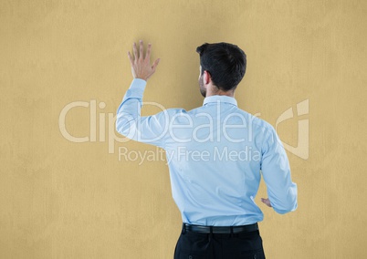 Rear view of businessman touching yellow background