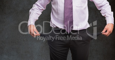 Midsection of businessman holding empty pockets against blackboard