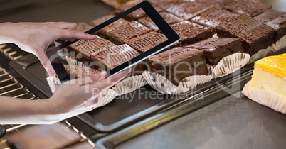 Hands photographing brownie through tablet PC