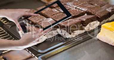 Hands photographing brownie through tablet PC