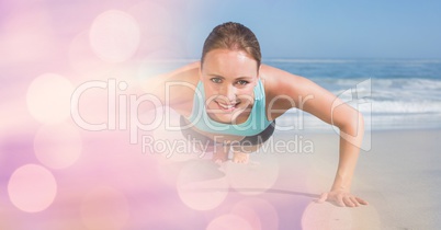 Confident woman doing push ups at beach