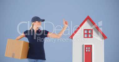 Delivery woman carrying parcel by 3d house