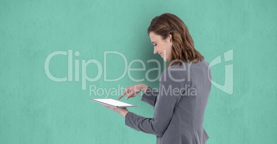 Businesswoman using digital tablet against green background