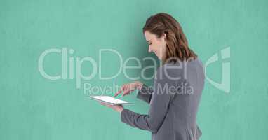 Businesswoman using digital tablet against green background