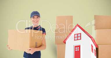 Delivery woman carrying cardboard box with house in background