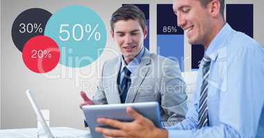 Businessmen discussing over tablet PC by graphs