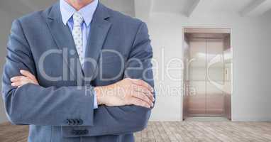 Midsection of businessman with arms crossed in office