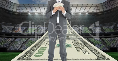 Businessman holding money at football stadium representing corruption