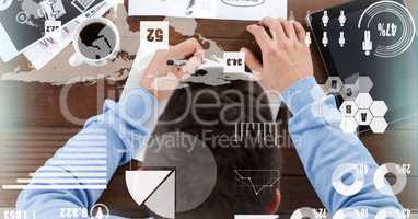 Top view of businessman working at table with overlays