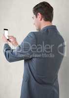 Businessman touching smart phone against gray background