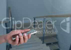 Hand holding a mobile phone device on stairs