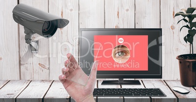 Hand holding glass screen with Security camera watching laptop identity App Interface