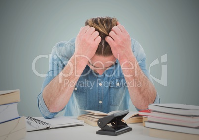 Stressed man at desk against light blue background