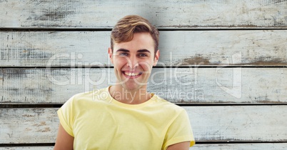 Portrait of man smiling over wooden wall